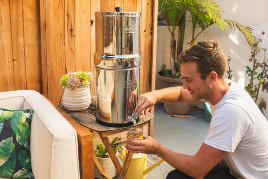 A man is pouring filtered water using Berkey water filter